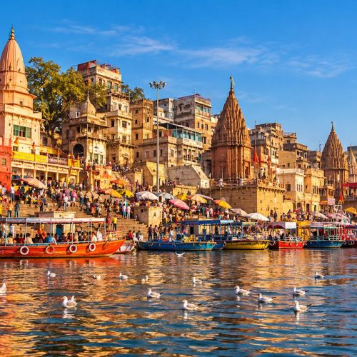 Dashashwamedh Ghat in Varanasi with historic temples, colourful boats and pilgrims along the River Ganges.
