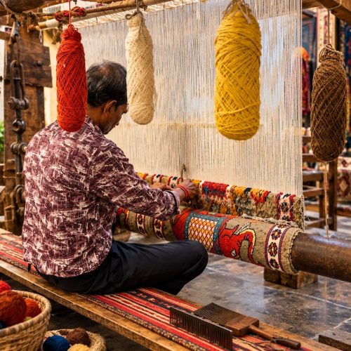Traditional carpet artisan weaving a handmade carpet in Jaipur Rajasthan