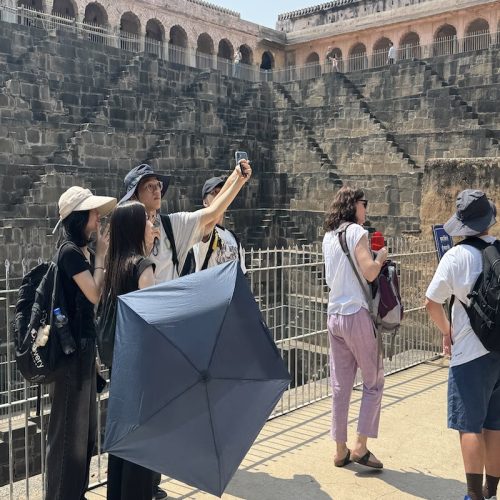 Travellers exploring Chand Baori stepwell in Abhaneri during a Golden Triangle tour